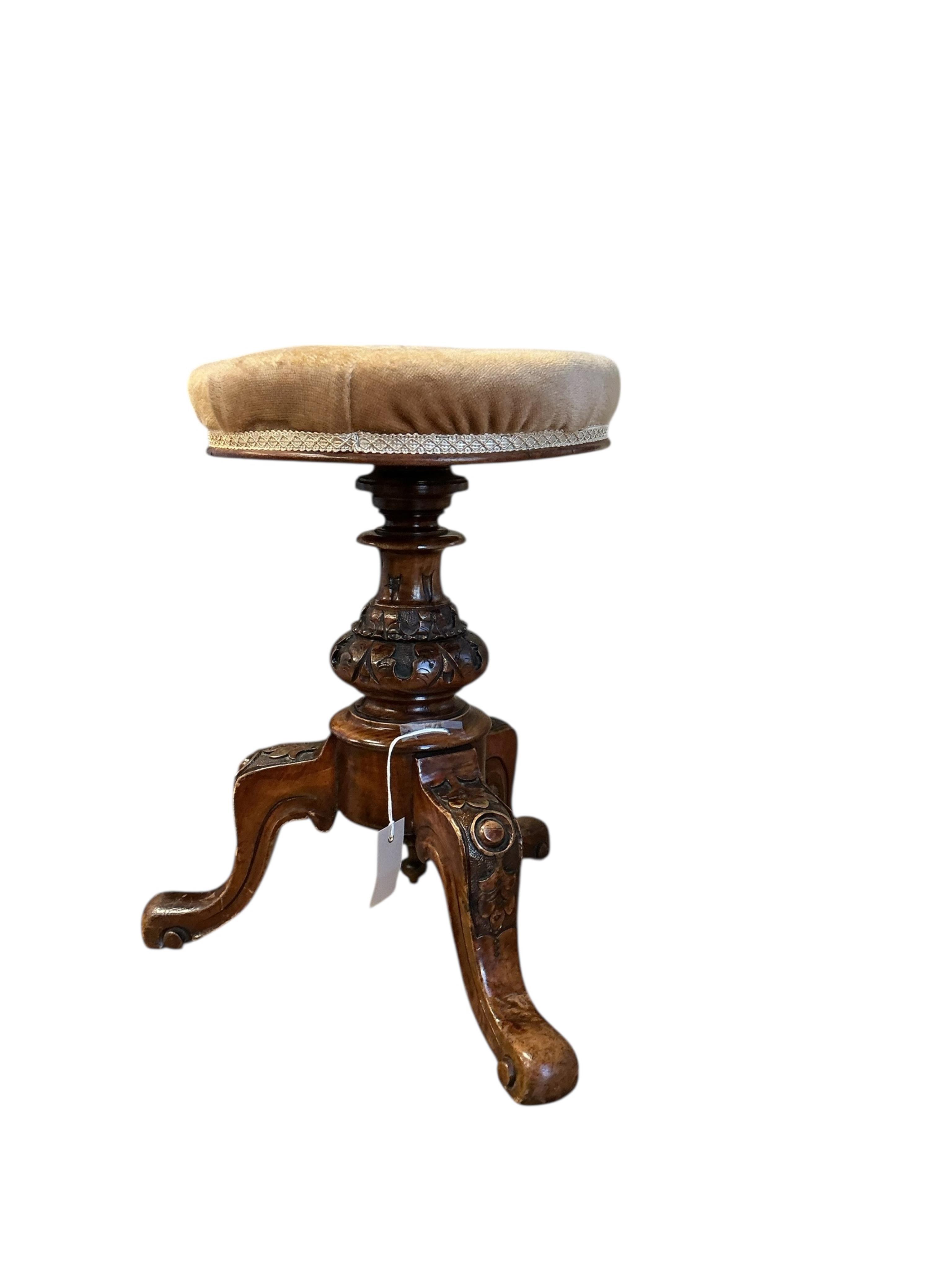 A Victorian walnut revolving piano stool
